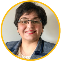 Headshot photograph of smiling woman with glasses, short dark hair, blue blazer, yellow border.